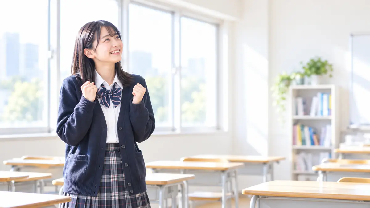 教室で笑顔でガッツポーズをする高校生